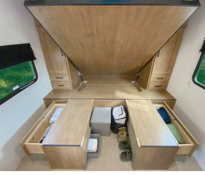 This RV rental bedroom features smart storage: the bed folds up, revealing pull-out drawers and compartments for maximizing space.. Coachmen fet257bhs-320 2021