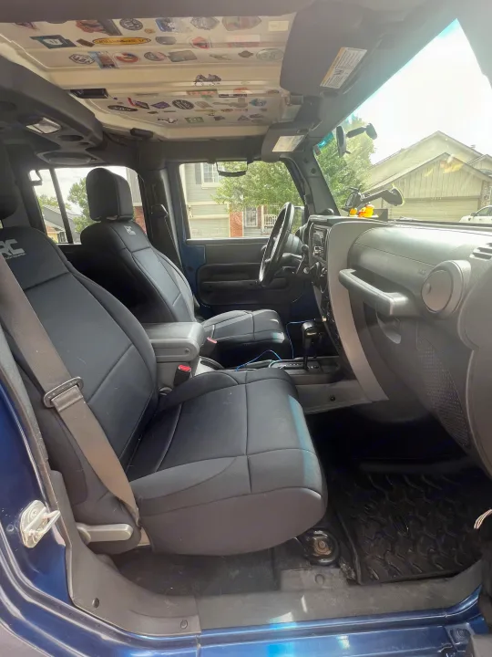 Modified Jeep interior showcasing custom seats and adventure stickers. Perfect for an rv rental getaway.. Jeep Wrangler 2010