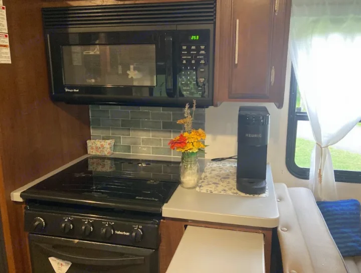 RV rental kitchen: compact design with microwave, stove, Keurig, and cozy dinette seating.. Georgetown GT3 2016
