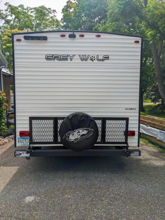 White Grey Wolf travel trailer rear. Perfect RV rental with spare tire, cargo rack, and MN plate RX61514.. Forest River Cherokee Grey Wolf 23DBH 2024