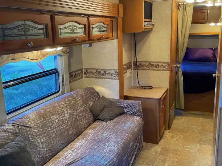 Experience comfort in this RV rental featuring a sofa, ornate cabinets, an entertainment area, and a cozy bedroom.. Dutchmen Dutchmen 2007