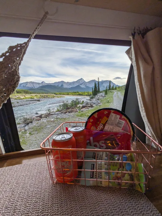 RV rental comfort: Popcorn, soda & trail mix in a basket, with a grand view of a mountain river and forest.. Chevrolet Express 2003