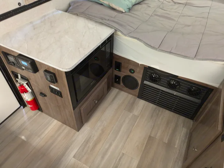 Tour this RV rental's compact living space: microwave, bed, controls, and safety features.. Rockwood A122s 2023