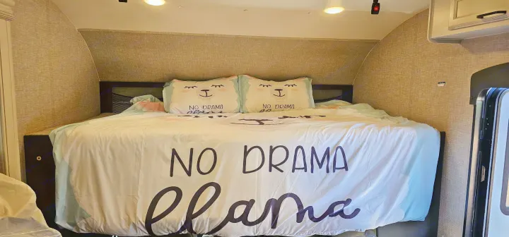 Cozy RV rental bedroom with 'No Drama Llama' bedding, perfect for comfortable travel and a fun interior.. Jayco Redhawk 2023