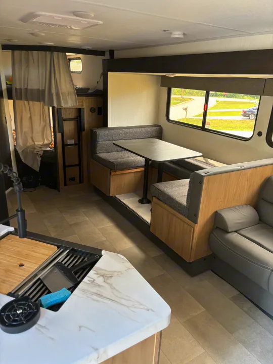Spacious RV rental interior featuring a dinette, bunk beds, and a functional kitchen for comfortable travels.. Forest River Cherokee 26DBH 2024