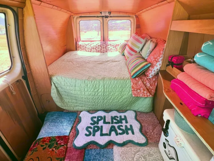 Explore this charming rv rental's interior: a comfy bed, pink walls, colorful towels, and a fun "Splish Splash" mat.. Ford E250 Eagle Camper 2006