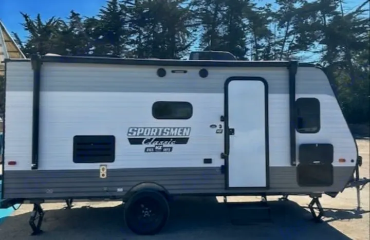 This gray and white Sportsmen Classic RV rental features an extended awning and stabilizer jacks, ready for adventure.. Sportsmen 181BH 2022