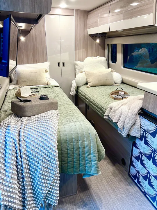 Cozy RV rental interior with twin beds, soft bedding, and compact storage, perfect for comfortable mobile living.. Thor Sequence 2023