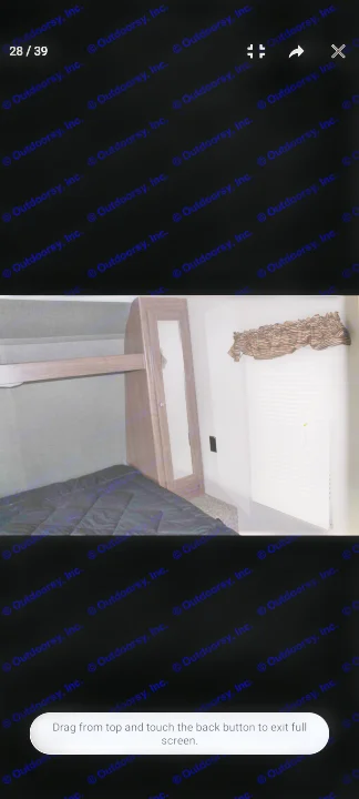 RV rental interior: a compact bedroom with a comfortable bed, built-in mirrored wardrobe, and window with blinds.. Keystone RV Hideout LHS 2018