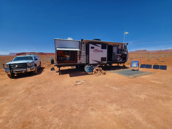 RV rental and truck in a spacious desert camp, powered by portable solar panels for an ideal off-grid adventure.. KZ Spree 301RIK 2015
