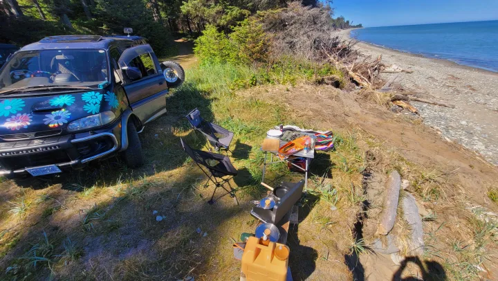 Rv rental camper van at a scenic beach with a cooking station and chairs set up for a coastal adventure.. MITSUBISHI Delica 1997