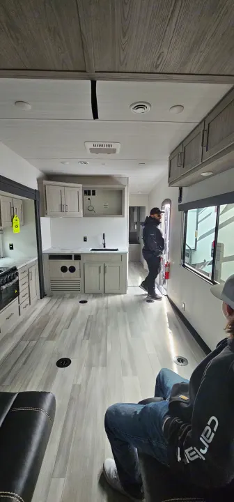 Inside a bright RV rental: a modern toy hauler interior featuring a kitchen and ample open living space.. Keystone Fuzion 2024