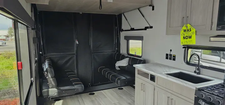 RV rental: Bright, versatile camper interior with kitchen, modular seating, and a rear ramp door for cargo.. Keystone Fuzion 2024