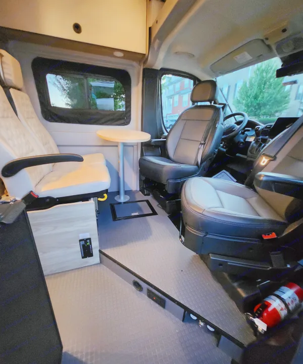 RV rental: Inside a modern camper van featuring swivel seating, a functional table, and a comfortable mobile living area.. Winnebago Solis 2024