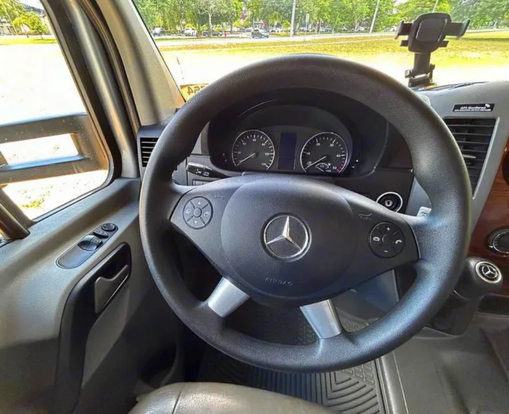 Driver's view in a Mercedes-Benz Sprinter RV rental: steering wheel, dashboard, gauges, and phone mount are visible.. Forest River Mercedes 2019