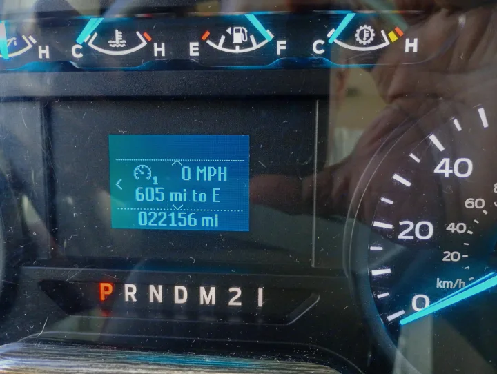 RV rental dashboard: Digital display shows 0 MPH, 605 miles to empty, 22156 total miles. Gear in Park.. Thor Motor Coach Hurricane 2022