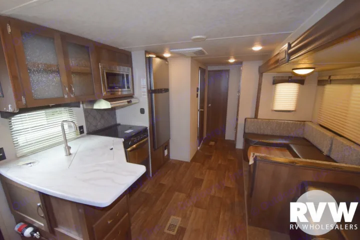 Spacious RV rental interior with a modern kitchen, microwave, stove, fridge, and a cozy U-shaped dinette.. Forest River Palomino Puma 2018