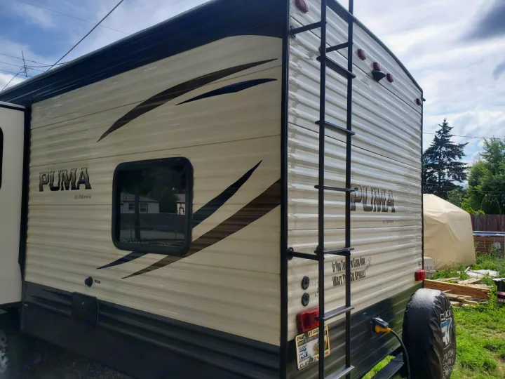 Experience an RV rental! This beige PUMA by Palomino travel trailer's exterior features a rear ladder, ready for your road trips.. Forest River Palomino Puma 2018