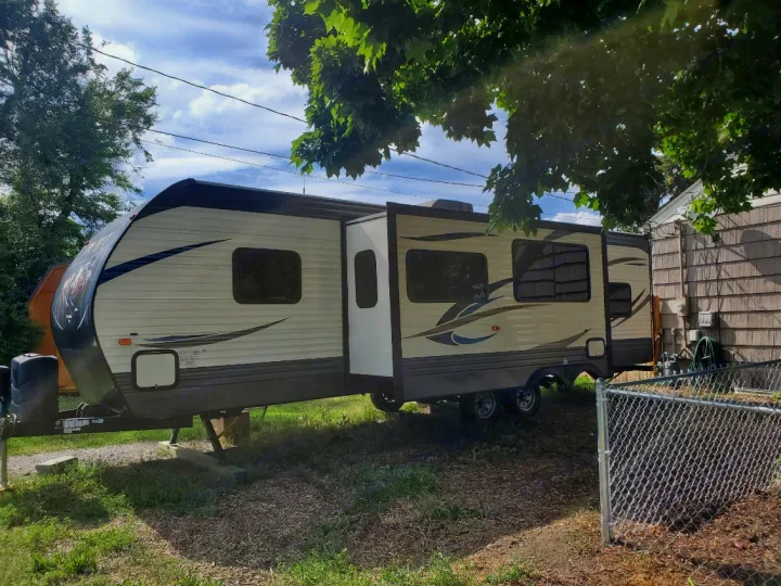 Spacious travel trailer, ideal for an RV rental. Parked outside with slide-out extended, ready for adventures.. Forest River Palomino Puma 2018