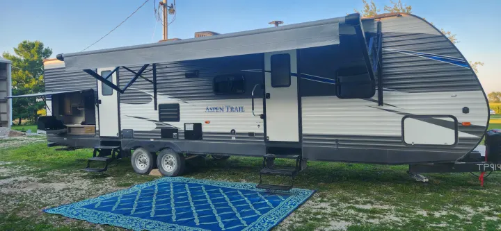 Aspen Trail RV rental with extended awning, outdoor kitchen, and ground mat for comfortable camping.. Aspen Trail Aspen Trail Trailer 2019
