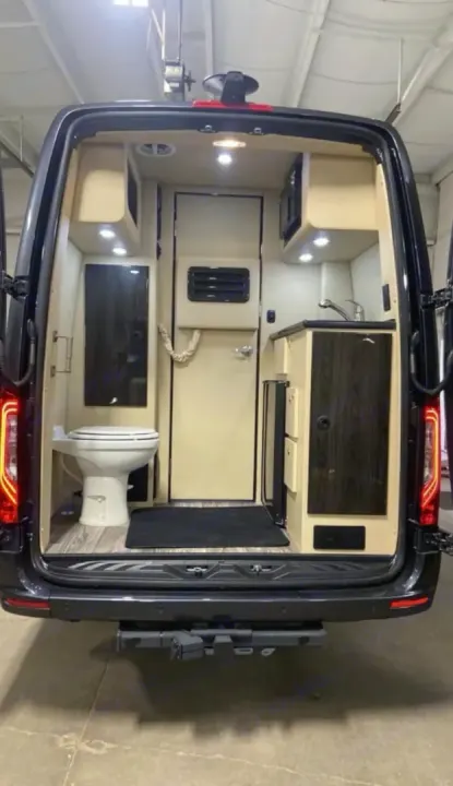 Step into this custom rv rental: a compact interior featuring a toilet, sink, and cabinets, ready for your road trips.. Ultimate Toys Ultimate Coach 2022