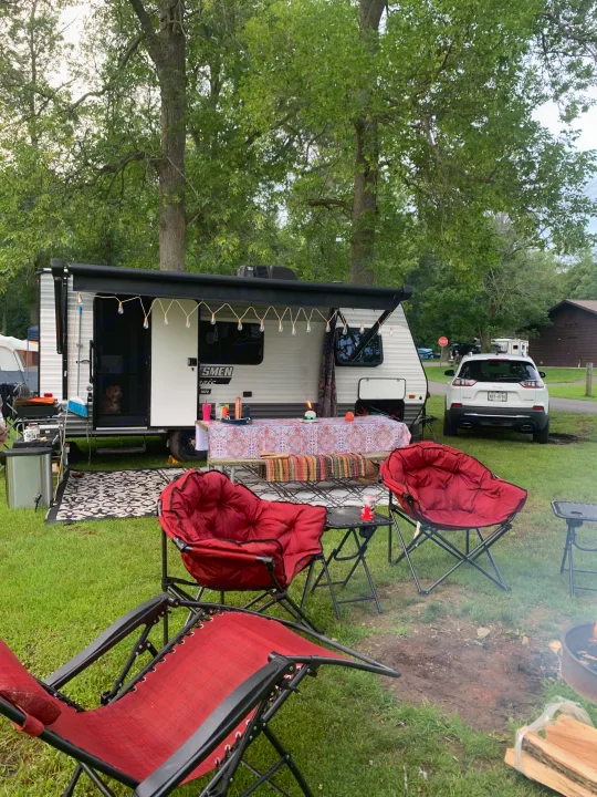 Peaceful RV rental camping site with string lights, red chairs, and a dog by the door. Enjoying an outdoor adventure.. KZ Sportsmen classic 160QB 2021