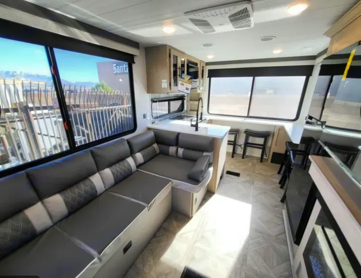 Spacious RV rental interior featuring a comfy L-shaped couch, full kitchen, and bright windows. Perfect for your next adventure.. Forest River Wildwood X-Lite 2024