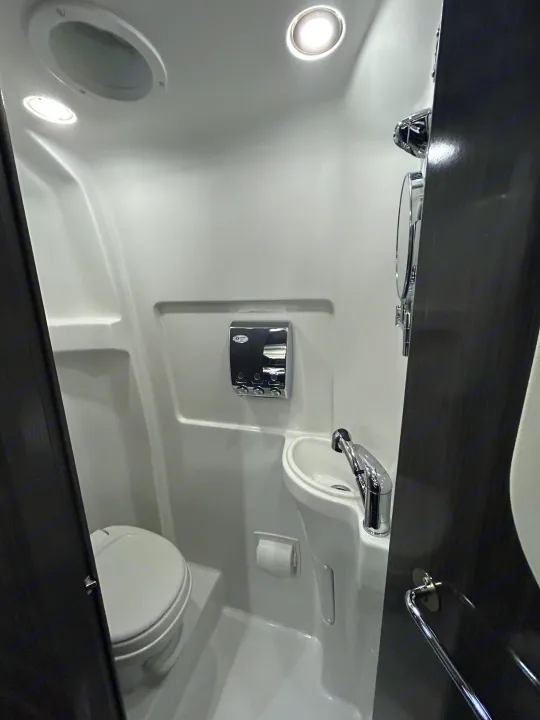 RV rental wet bath with toilet, sink, dispenser, and bright lights. Compact design for travel.. Airstream Interstate 2016