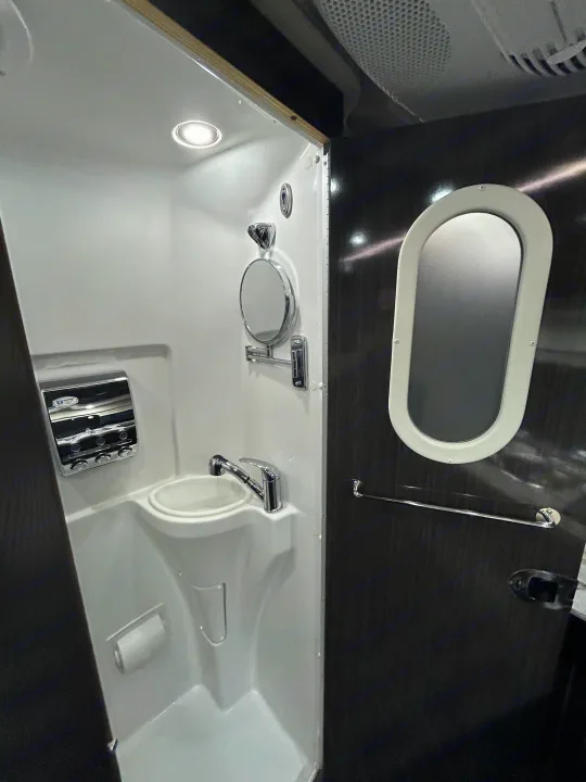Compact RV rental bathroom featuring sink, wall mirror, integrated shower space, and essential amenities for travel.. Airstream Interstate 2016