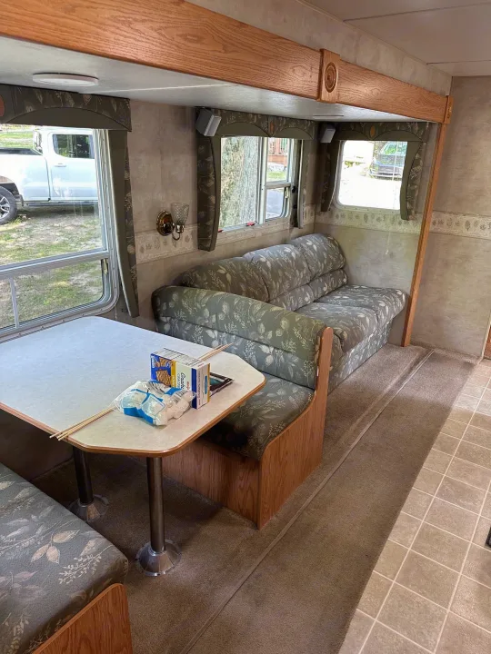 Inside a spacious RV rental: dinette, sofa, and s'mores supplies on the table, offering a cozy camp setup.. Jayco Jay Flight 2003