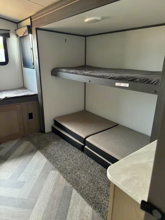 Cozy RV rental interior featuring a bunk bed, versatile floor cushions, and durable flooring for travel comfort.. Heartland Other 2021