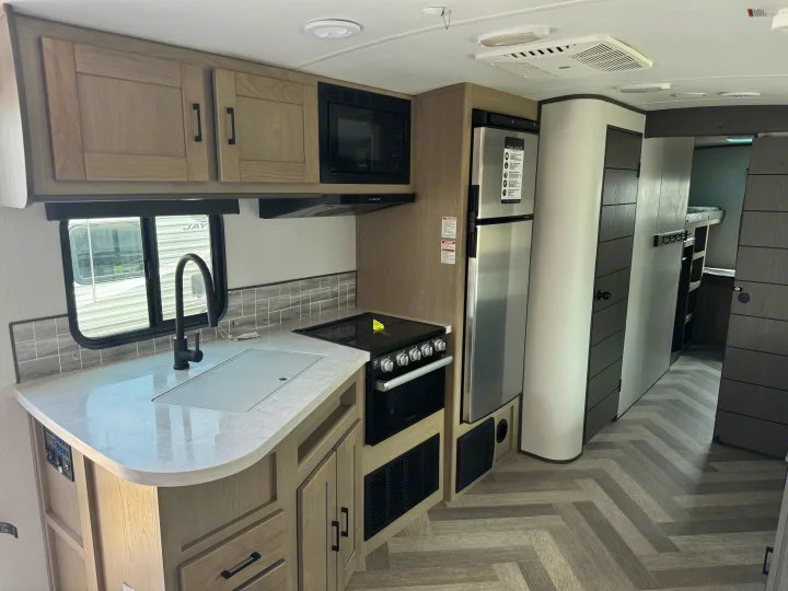 Modern RV kitchen with sink, stove, fridge, and bunk beds. Perfect for your next RV rental adventure.. Heartland Other 2021