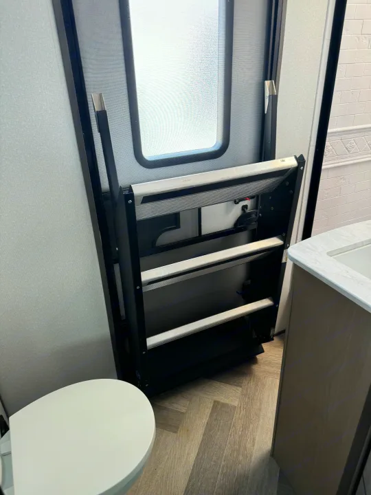 RV rental: Fold-up entrance steps by a compact bathroom with toilet & sink. Smart interior design for campers.. Heartland Other 2021