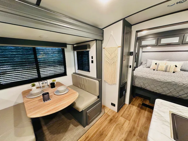 This modern RV rental features a cozy dinette and a comfortable bedroom, perfect for your next road trip adventure.. Keystone RV Bullet Ultra Lite 2023