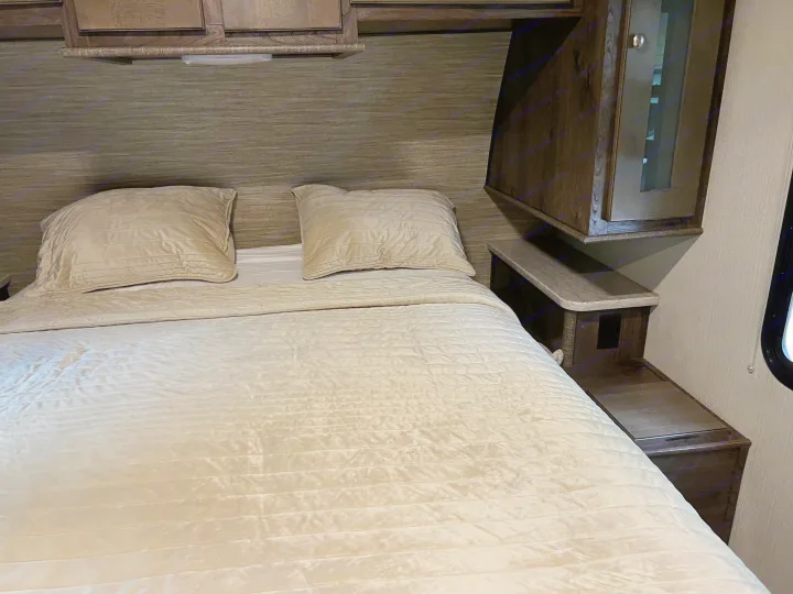 RV rental interior: a neatly made bed with light bedding, wood headboard, and built-in storage cabinets.. Cruiser Rv Corp Other 2018