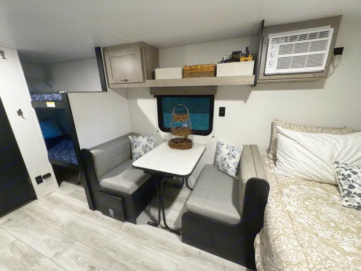 Spacious RV rental interior featuring a cozy dinette, convenient bunk beds, and a comfy sleeping area.. Cruiser RV Avenir 2024