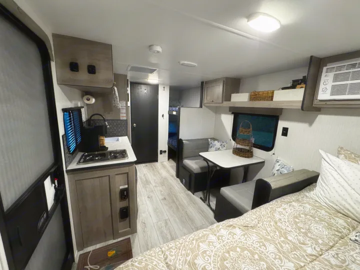 This RV rental offers a compact interior with a full kitchenette, dining booth, main bed, and bunk beds, ideal for family travel.. Cruiser RV Avenir 2024
