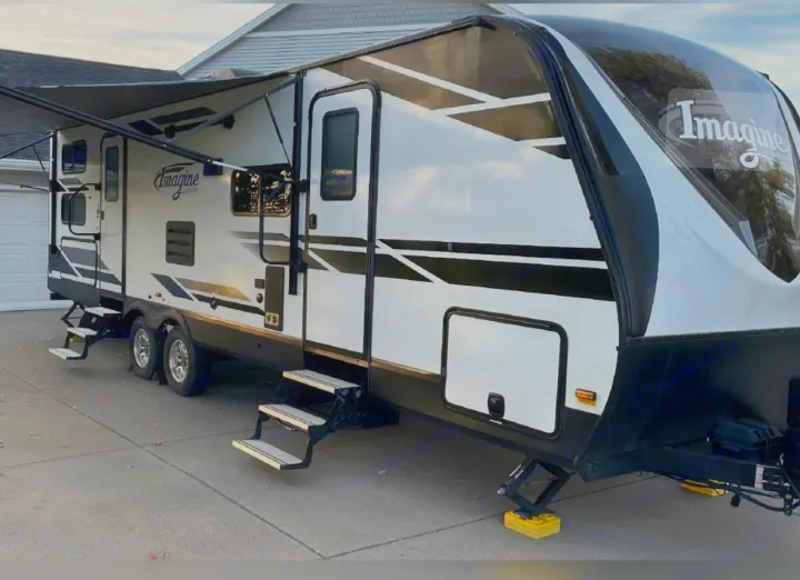 Explore the open road! This spacious white and black travel trailer, an Imagine **RV rental**, is parked and ready for your adventure.. Grand Design Imagine 2020