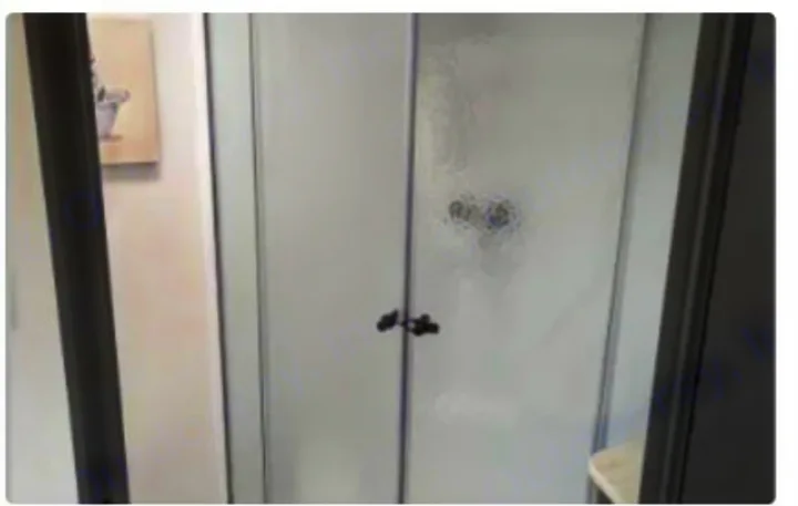 Inside an RV rental: a modern shower stall with frosted glass doors & black handles. Ready for your road trip comfort.. Keystone RV Bullet Crossfire 2023