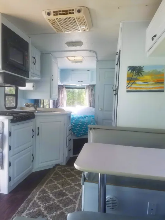 RV rental: Bright, renovated interior with a white kitchen, dining area, and sunny bedroom.. four winds majestic 2004