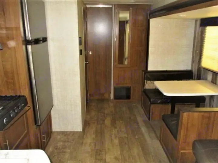RV rental interior: kitchen with a refrigerator, a hallway, and a dinette with bench seating.. Gulf Stream Kingsport 2020