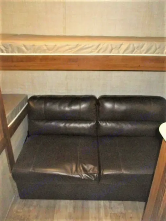 RV rental: Cozy interior with a bunk bed over a dark, two-seat sofa. Perfect for families.. Gulf Stream Kingsport 2020