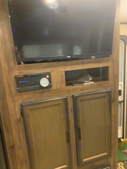RV rental living area: wood entertainment center with a TV, stereo, and storage cabinets.. Heartland RVs Mallard 2021