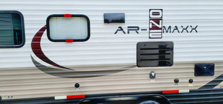 Side of an AR-ONE MAXX RV rental with windows, utility hookups, and graphic design for easy camping trips.. Starcraft AR-One Maxx 2017