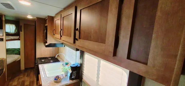 RV rental: Interior view of an RV, showing kitchen with sink, stove, cabinets, and bunk beds in background.. Starcraft AR-One Maxx 2017