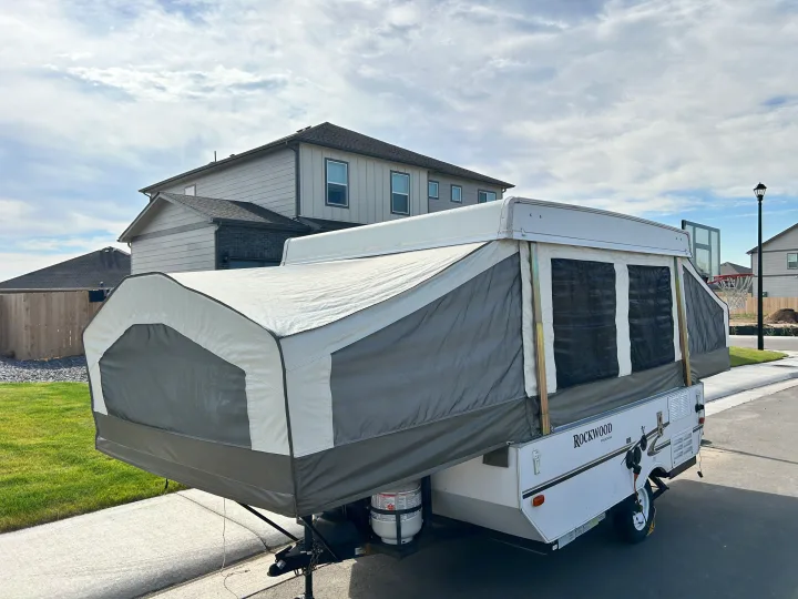 This Rockwood Freedom pop-up camper, perfect for an rv rental, is extended and set up in a residential area.. Forest River Rockwood Freedom 2012