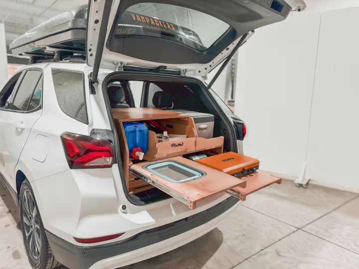 White SUV with custom car camping setup. Rear pull-out kitchen features a sink, stove & water. Your next rv rental adventure awaits!. Ford Escape 2025