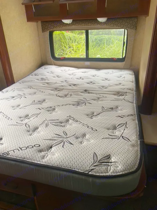 Cozy RV rental bedroom featuring a clean iBamboo mattress, with a view of nature outside.. Forest River Sunseeker 2014
