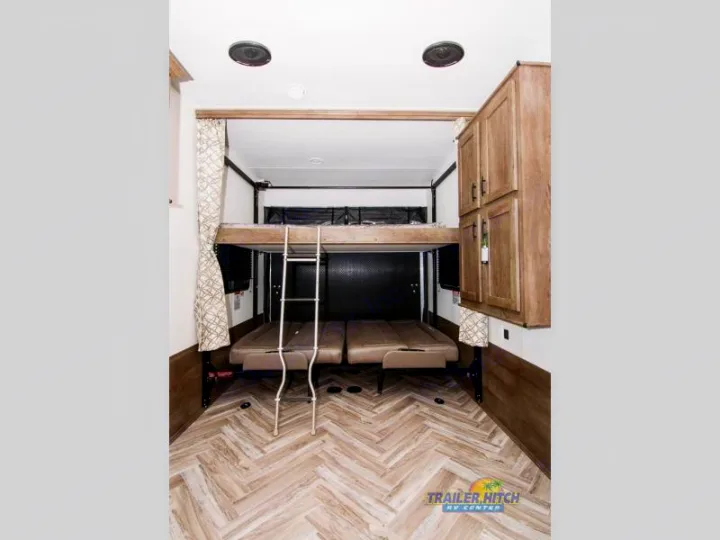 Experience comfortable RV rental living with this toy hauler's versatile bunk bed and seating area, perfect for adventurers.. Forest River Stealth 2020