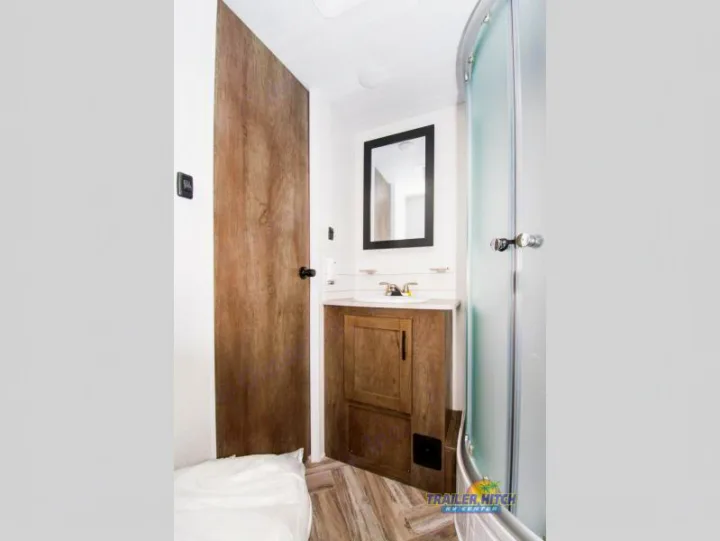 Clean RV rental bathroom with vanity, mirror, and curved shower. Ideal for your mobile adventures.. Forest River Stealth 2020